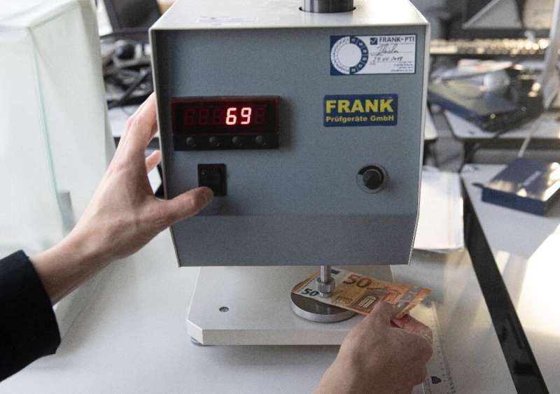 European Central Bank experts use machines to check the thickness of euro bills